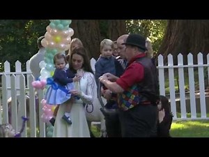 Princess Charlotte chases bubbles and Prince George plays with balloons