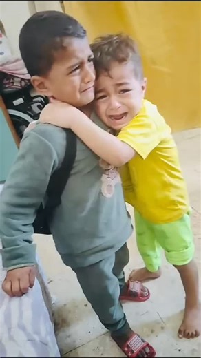 Two brothers say goodbye, and the world feels impossibly heavy in that moment. Only one will be evacuated for medical care. His older brother, barely holding it together, wraps his arms around him, trying to shield him from fear, pain, and the uncertainty ahead. For a brief moment, all the chaos, the destruction, the endless struggle fades. It’s just two hearts beating together, trying to stay strong. The older brother’s hands tremble, his eyes well up, but he swallows his tears — because he has