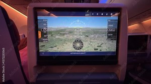 Airplane economy class seat monitor displaying flight route information, current location, estimated arrival time, and travel details for passengers.
