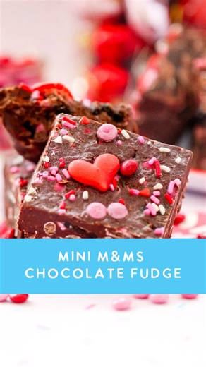 Nothing like biting into rich and creamy chocolate fudge 🍫 Ingredients 3 cups semi-sweet or milk chocolate chips 1 (14 oz) can sweetened condensed milk 4 tablespoons unsalted butter 1-2 tablespoons heavy cream 1 teaspoon vanilla extract ¼ teaspoon salt 1 cup M&M Minis- Valentines ½ cup crushed chocolate sandwich cookies Topping Mini M&M’s Valentine’s sprinkles Heart royal icing Instructions Line an 8x8 pan with parchment paper and lightly spray. In a completely dry saucepan over low heat, add t