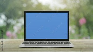 Power button icon on modern laptop computer screen on wooden table over blur pink flower and tree in park, Business start up online concept