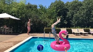 Incredible moment a swimmer dives through an inflatable flamingo