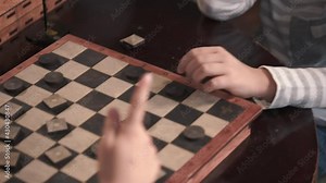 Children play checkers. Close up footage of field for playing checkers with chips.