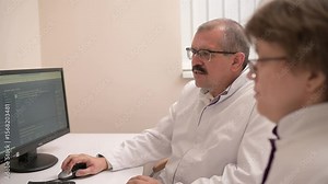 Two healthcare professionals in a clinical setting review patient data collaboratively using advanced computer systems