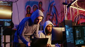 Rogue programmers in secret hideout discussing ways to best hide their online activity after stealing data from victims through hacking, trying to avoid being detected by cybercrime law enforcement