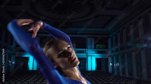 Group young skillful ballerinas dancing modern ballet on the stage of large hall. Girls looking at auditorium. Dress rehearsal before performance.