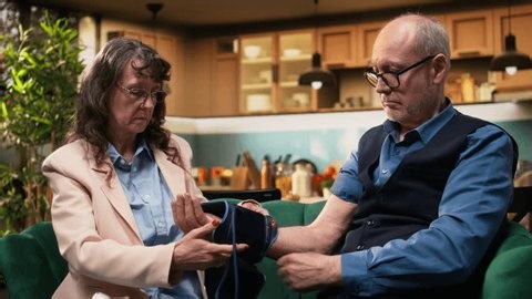 clip-4013367061-elderly-man-woman-using-blood-pressure-monitor