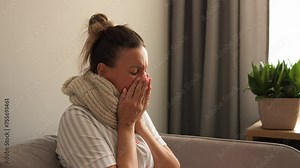 At home woman contends with stubborn cold virus her every cough reminder of her discomfort Experience relentless coughing as she navigates through her day seeking respite from relentless coughing fits