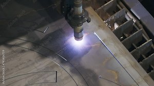 Metalworking automated laser cuts out the shape in the steel sheet. Metalworking automated laser processing steel component. Metalworking automated laser operating at the production facility