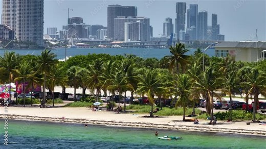 Hobie Island Beach on Virginia Key and downtown office district of Miami Brickell in Florida, USA. Waterfront skyscraper buildings in modern megapolis.