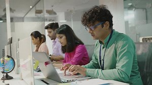 Young indian man using laptop planning for success in modern office, businessman typing and watching notebook with confident, executive with handsome and smart business concept.
