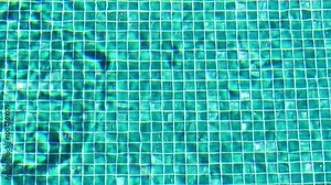 Turquoise colored bottom of swimming pool filled with water. Light reflections on the bottom of a swimming pool.