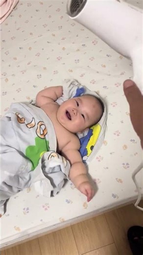 Baby wiggles with joy at the sound of a hair dryer in Jiangsu, China