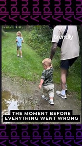 Young child approaches puddle and unexpectedly slips in