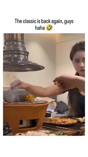 @decode.video on Instagram: "The post revives a viral meme video showing an Asian woman casually grabbing and eating scorching-hot grilled corn bare-handed at a Korean BBQ table, ending with a confident smile that amplifies the humor of her nonchalant toughness. Claimed as a "classic," the clip echoes earlier iterations circulating online since at least 2023, often captioned to playfully subvert gender norms by portraying women as impressively resilient in "manly" feats like enduring heat. With