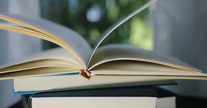 Open book on top of a stack of books