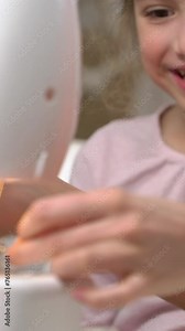 Mother teaching her little daughter to sew using a sewing machine in the nursery at home. Children's craft, education and training. Vertical video for smartphone screen, for target social media