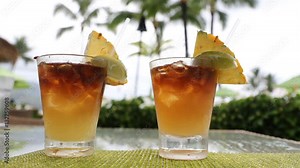 Alcoholic drinks for romantic couple standing on table on vacation resort. Close up of two Mai Tai drinks on Hawaii. Typical Hawaiian drink.