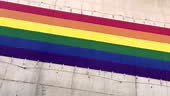 Panning shot of pride flag banner over wall for Pride Day celebration...
