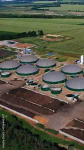 Organic biogas plant in the green farm plantations. Biomass production for saving nature resources. View from above. Vertical video.