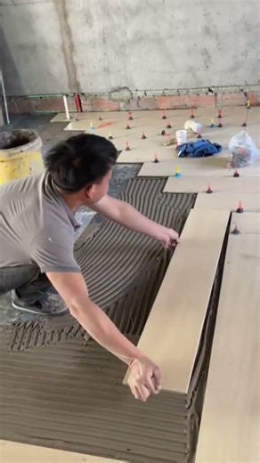 Tiler Installing Large Format Wood-Look Porcelain Floor Tiles Using Tile Leveling System