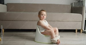 Side view of adorable smiling girls sitting on chamber pot,potty training hygiene. child learning sit on toilet wc seat at home. Kid about two years old. High quality 4k footage Stock Video