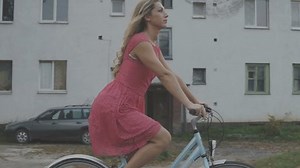 Beautiful girl riding a bicycle on a road in the countryside. HD