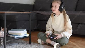 Little girl playing internet video game using remote controller