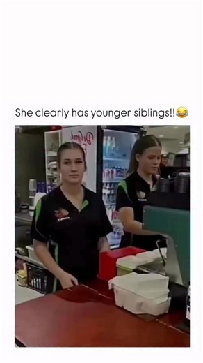 Know in Minutes on Instagram: "The video begins with two young women, seemingly working at a juice bar or cafe, standing behind a counter. They are wearing matching black and green polo shirts with a logo. The woman on the left has her hair up in a ponytail and is facing the camera, while the woman on the right is partially obscured and appears to be working the register or preparing something. Suddenly, a very loud, high-pitched scream or screech is heard off-camera. Both women immediately reac