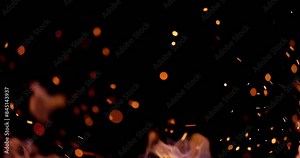 Close-up. Wind blows yellow flames and small glowing sparks from hot coals. Sparks fill all dark space around them and make it light up dark starry sky with millions of bright stars. AD. Copy space.