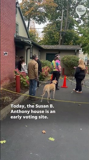 Women place 'I Voted Today' stickers on Susan B. Anthony's headstone