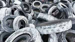 Pile of waste tires, dumped and ready for recycling. Heap of old scrap tyres, discarded and worn, painted white. Environmental protection and rubber pollution prevention. Stock Video
