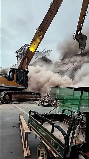 Dangerous powerful excavator operator high reach demolition excavator ripping down building
