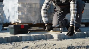 Paver Installer Using Hammer to Secure Paving Stones