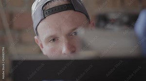 Close up hands of the carpenter in the gloves marking the line on the MDF plate where should be cut, then taking away the board. Working process. Concept of hand manufacturing