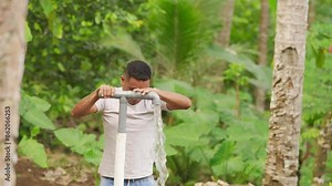 Southeast Asian villager collecting water in rural asia, manual pump, groundwater tank, sustainable system and access for farming communities