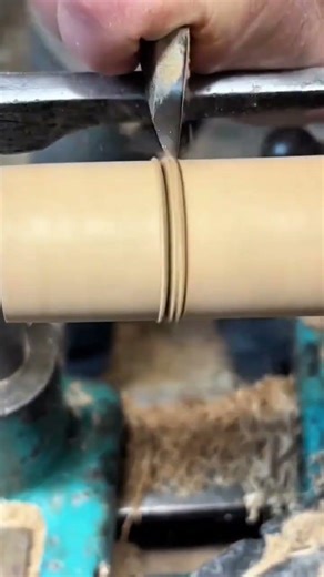 Carving and smoothing a cylindrical wood piece using a sharp chisel on a lathe machine