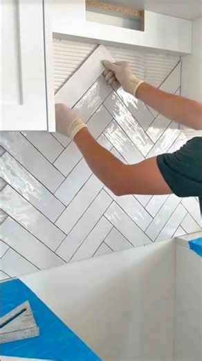 Installing wall tiles in a herringbone pattern