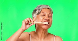 Green screen, mature woman or brushing teeth with dental toothpaste for healthy oral hygiene grooming. Eco friendly, cleaning portrait or senior person with bamboo wooden toothbrush for wellness