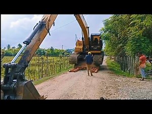 The process of loading and unloading an excavator onto a self-loader.