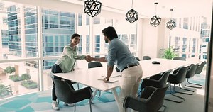 Beautiful businesswoman arriving for job interview, shaking hands with the HR manager in corporate meeting room. Confident and professional woman makes strong impression, successful hiring concept