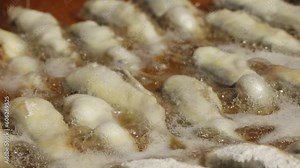 Fresh herring from the sea was fried in oil on a pan.