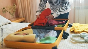 Tourist female packing baggage with clothes, accessories, shoes preparation to tourism. Summer holidays, voyage and traveler concept. High quality FullHD footage.