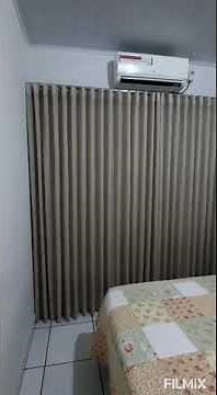 Cortina debaixo do ar condicionado no varão deslizante. Praticidade e elegacia para seu quarto......