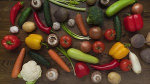Moving vegetables on kitchen table, wooden background - stop motion animation, 4k, place for title