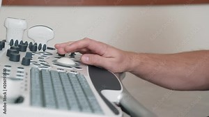 The doctor's hand close-up. How does the ultrasound machine work. Doctor works on the ultrasound machine clicks on the buttons. Conduct an ultrasound in the hospital. The uvist doctor works on modern