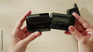 Pager beeper device close up on a desk, retro phone 90s instant communication and connection, sms messaging in the early 80s 90s digital age