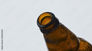 Beer bottle cap popping off closeup. Craft cold beverage spilling under pressure