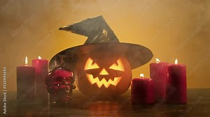 Halloween scary pumpkin in witch hat. Halloween pumpkin smile and scary eyes with smoke at yellow background. Jack O' Lantern symbol. Spooky face glowing in dark. 4K, UHD