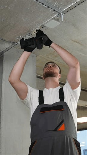 clip-4027389331-construction-worker-drilling-into-concrete-ceiling